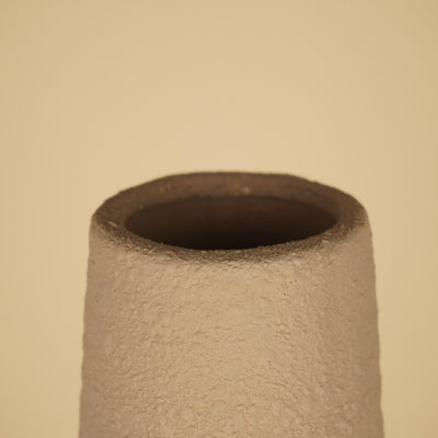 Detail van de smalle ronde opening met dikke, ruwe rand en donkere binnenzijde van een beige vaas.