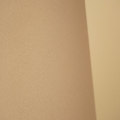 Detail van het matte, zandkleurige oppervlak van de vaas met een fijne korrelstructuur.